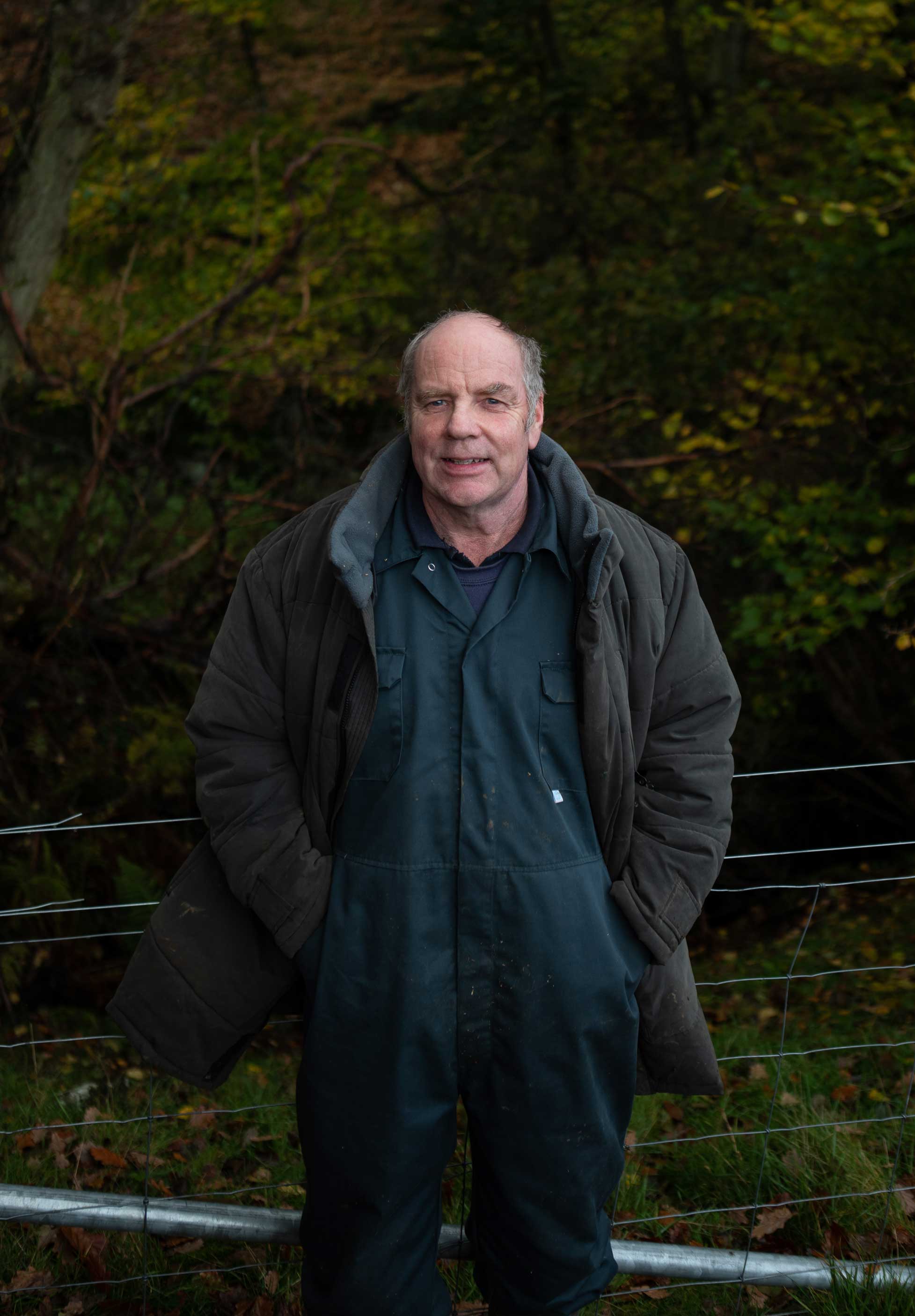 Portrait photo of Stephen Sanderson stood in front of a woodland. Credit Charlie Fox.
