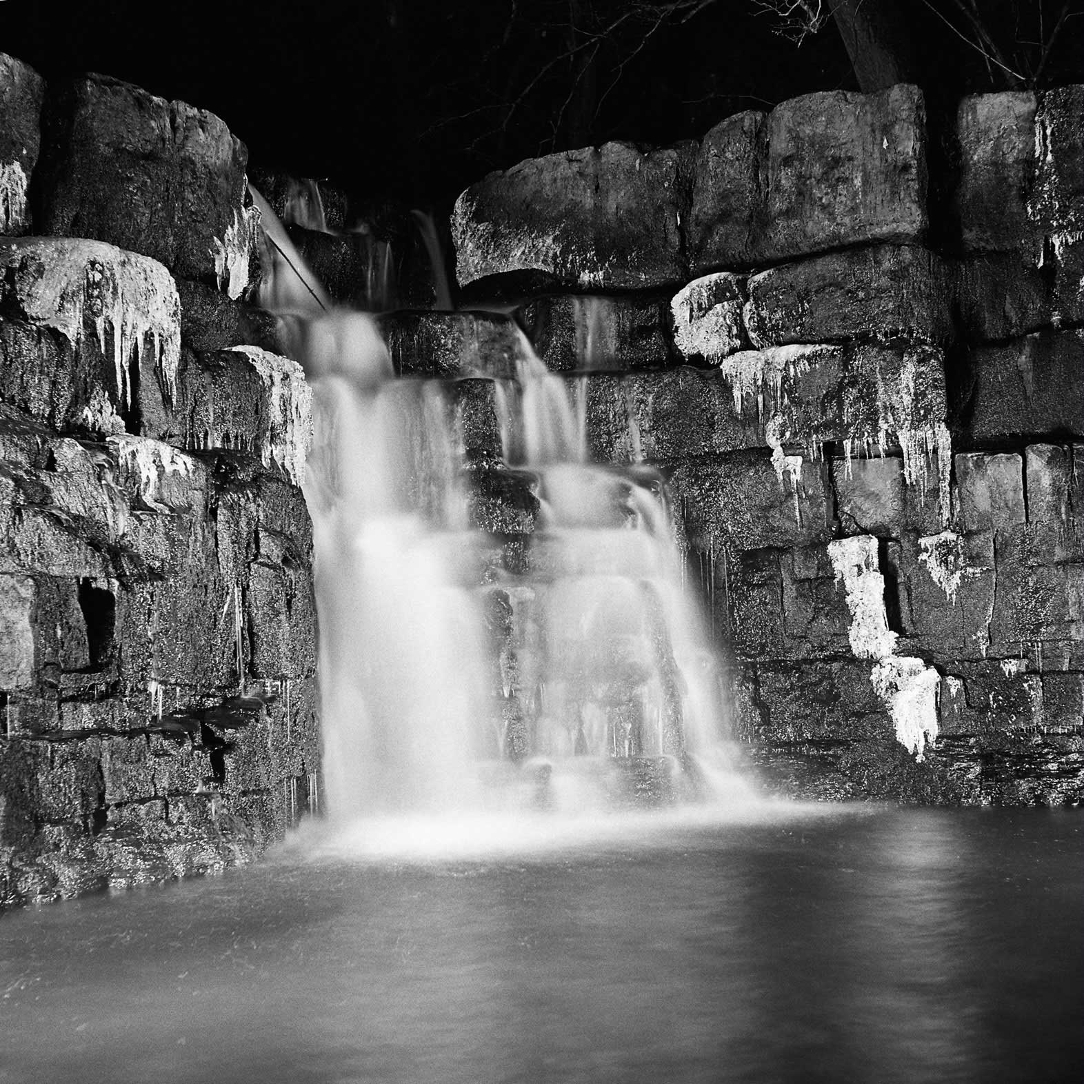 Nighttime - a black and white photograph of a waterfall by John Arnison.
